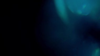 Mavi mercek parlayan ışık bokeh örtüleri, yanan alev arka planı. Açık Mavi Fişekler 4K görüntüler, görüntülerinizi birleştirmek, videoyu biçimlendirmek, geçiş için. Odaklanmış lamba flaş ışını etkisi. Işık vuruşları