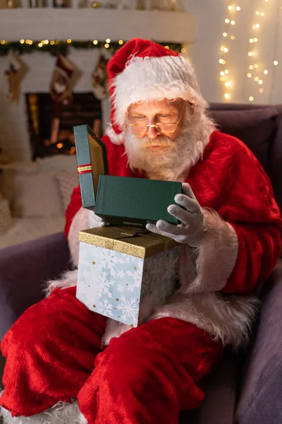 Śmieszne Santa Claus Otwarte pudełko z prezentami świątecznymi. Wybieram prezenty noworoczne. Mikołaj prezenty pod choinką. Grudzień Wieczór przed Wigilią. Koncepcja Nowy Rok Dream Christmas Spirit. — Zdjęcie stockowe