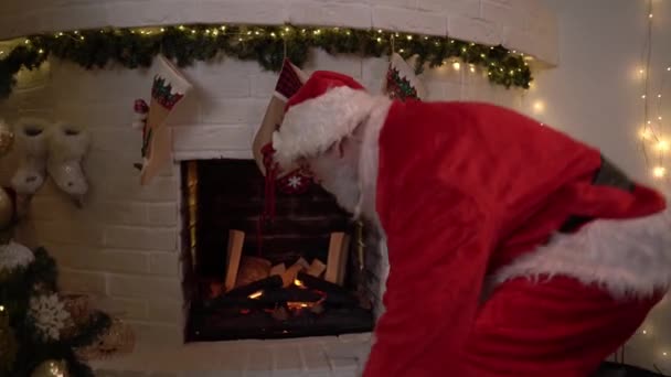 Забавный Санта Клаус сидит у камина и не знает, как туда добраться. Санта Клаус был удивлён. Рождественский дух, магия, концепция снов — стоковое видео
