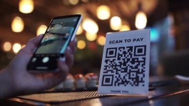 Akıllı telefonla QR kodu taranıyor. Kadın, kafedeki akıllı telefondaki başvuru formunu kullanarak barkodu okuyor.