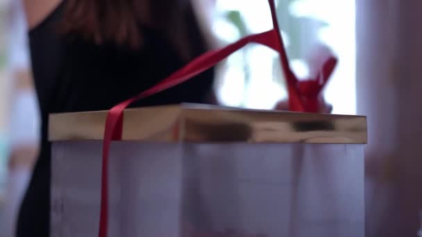 Девушка открывает коробку с праздничным тортом. Клубничный торт приготовлен к празднованию дня рождения дома — стоковое видео