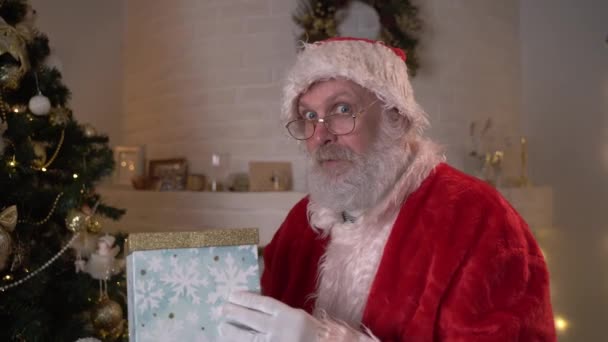 Vtipný Santa Claus se připlíží a dá nový rok dárek pod vánoční stromek. Večer před Vánocemi. Nový rok sen koncert vánoční duch. — Stock video