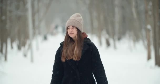 Attrayant jeune belle femme se promène dans une forêt enneigée d'hiver et souriant. Happy girl portrait dans la forêt d'hiver. Mode de vie, bonheur, concept de vacances. Joyeux — Video