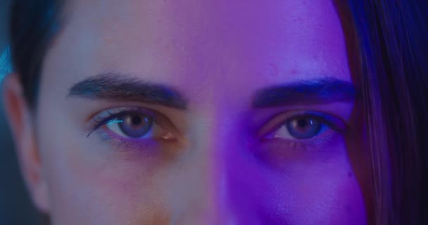 Beautiful eyes of woman in colourful neon. Abstract Shot of Female Face and Skin with Multi-Colour Flickering of Modern Street Signs. Concept of Young Lady in Red Lighting — Stock Video