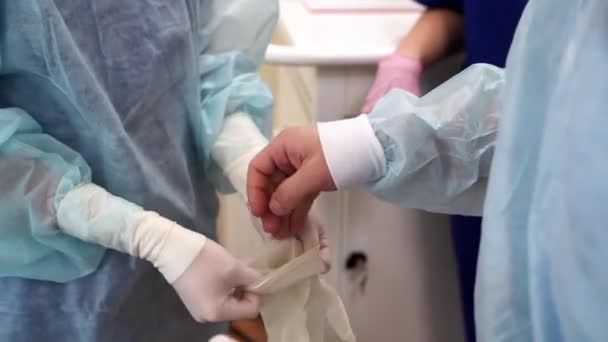 Chirurg si před operací nasadil ochranné rukavice. Zavřít pohled . — Stock video