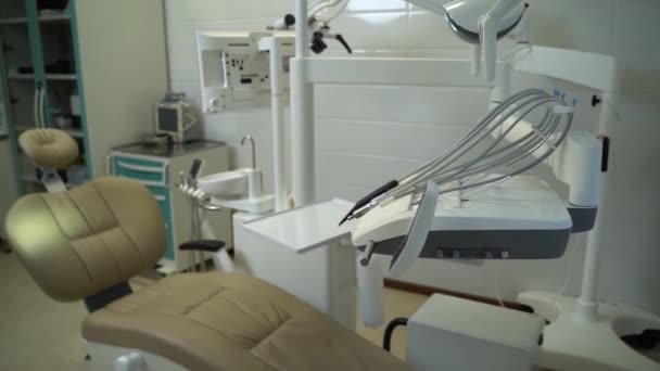 Nowoczesne wnętrze gabinetu dentystycznego z krzesłem i narzędziami. — Wideo stockowe