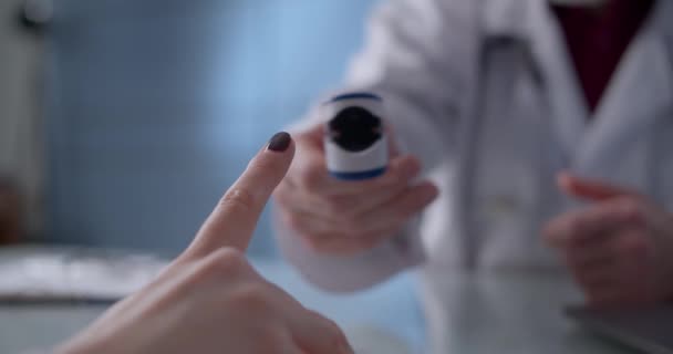 Hastanın klinikteki randevusunda kullanılan nabız oksimetresinin yakından görüntüsü. Salgın sırasında sağlık kavramı — Stok video