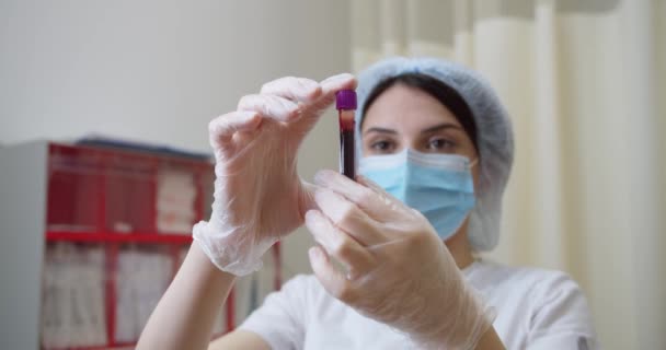 Νοσοκομειακή νοσοκόμα στο σύγχρονο εργαστήριο close-up. Δείγμα αίματος για αντισώματα του ιού του στέμματος από νοσηλεύτρια. Ιατρική διάγνωση για τη δοκιμή του κορωναϊού ή τη θεραπεία της γρίπης από επιστήμονα μικροβιολογίας — Αρχείο Βίντεο