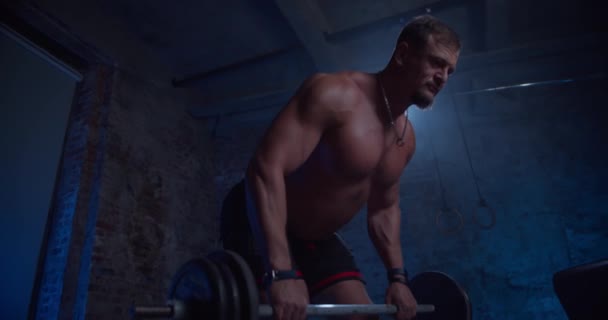 Svalnatý muž dělá Deadlift a kadeře s těžkým činelem. Sportovní mužský trénink bez košile, cvičení síly, síly a vytrvalosti s Barbellem. Cvičení v Hardcore tělocvičně — Stock video