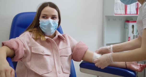 Krankenschwester entnimmt venöses Blut zum Test. Labor in Klinik. Laborassistentinnen entnehmen Blutproben von Patientinnen, um sie im echten Krankenhaus auf Coronavirus zu testen. Gesundheitskonzept — Stockvideo