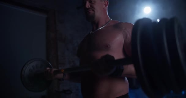 Svalnatý muž dělá Deadlift a kadeře s těžkým činelem. Sportovní mužský trénink bez košile, cvičení síly, síly a vytrvalosti s Barbellem. Cvičení v Hardcore tělocvičně — Stock video
