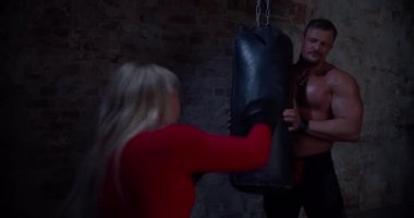 Boks koçu, şehir spor salonunda yumruk pratiği yapan bir bayan sporcuya özel eğitim veriyor. Güçlü agresif sarışın kadın ringde feminizmin ve başarılı kadınların sembolü olarak boks yapıyor.
