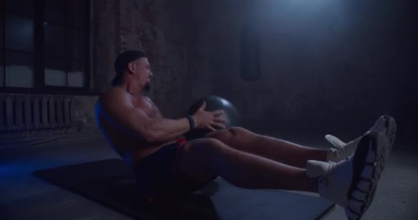 Svalový fitness muž cvičení s pilates míč v tělocvičně. Muž atlet dělá cvičení pomocí medicínské koule. — Stock video