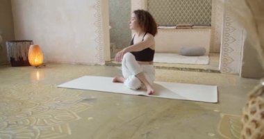 Sportif Kıvırcık Saçlı Kadın Yoga Germe Egzersizleri Yapıyor. İnce kız yoga yapıyor Parlak, atmosferik yoga odasında Sabahları