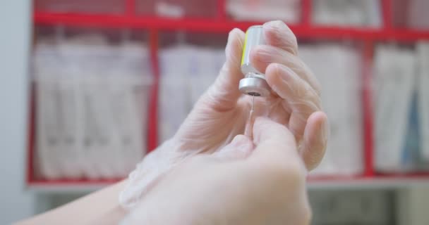 Sluiten van verpleegkundige handen die een coronavirus, mazelen of griepvaccin in de injectiespuit houden. Geneeskunde, wetenschap en gezondheidszorg — Stockvideo