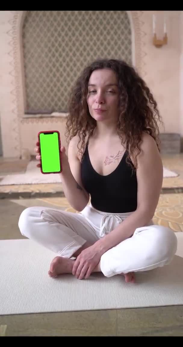 Curly-Haired trener fitness kobieta pokazuje ćwiczenia online za pomocą smartfona z zielonym ekranem. Nauka i nauka online, aktywny zdrowy tryb życia sport trening kobiet wellness i kryty — Wideo stockowe