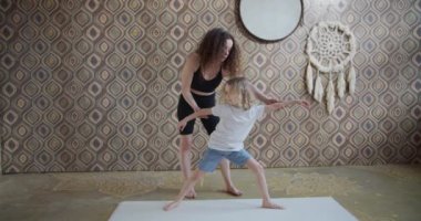 Modern, mutlu, sağlıklı aile çocuğu oğul ve genç anne yoga egzersizleri yaparken eğleniyor, düşünceli anne küçük tatlı çocuğa yoga stüdyosunda meditasyon yapmayı öğretiyor.