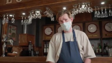 Tıbbi maskeli bir adamın portresi, barmen kafesi ya da restoranları olan ve Coronavirus karantinasından sonra tekrar açılan bir yer. Küçük işletme kapanış sonrası kilitleme.
