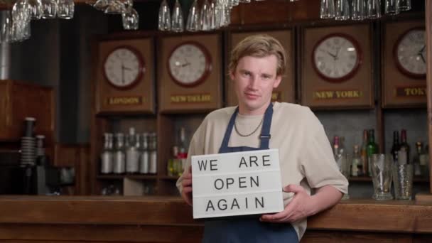 Portret mężczyzny ze znakiem świetlnym We Are Open Again, właściciel kawiarni barman lub restauracji i biznesu wznowić po kwarantannie koronawirusów. Małe przedsiębiorstwa po zamknięciu COVID. — Wideo stockowe