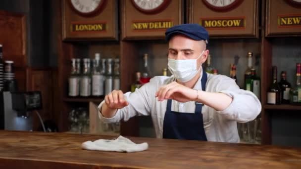 Genç garson barmen ya da kafe restoranının temizlik barında çalışan, müşterilerden sonra deterjan ya da dezenfektan sıkan, covid koronavirüs koruması, kamu güvenliği — Stok video