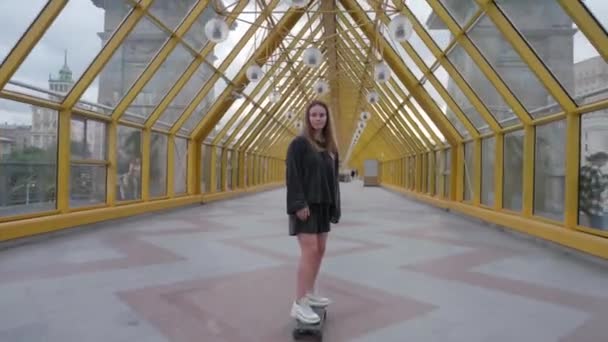 Felice cura ragazza gratis skateboard in tunnel giallo — Video Stock