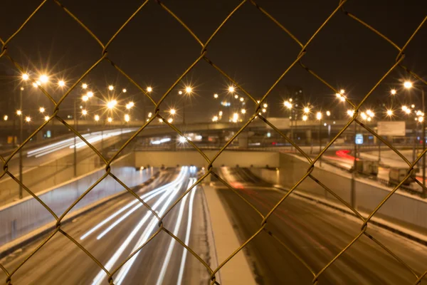 Strada notturna attraverso le sbarre — Foto Stock