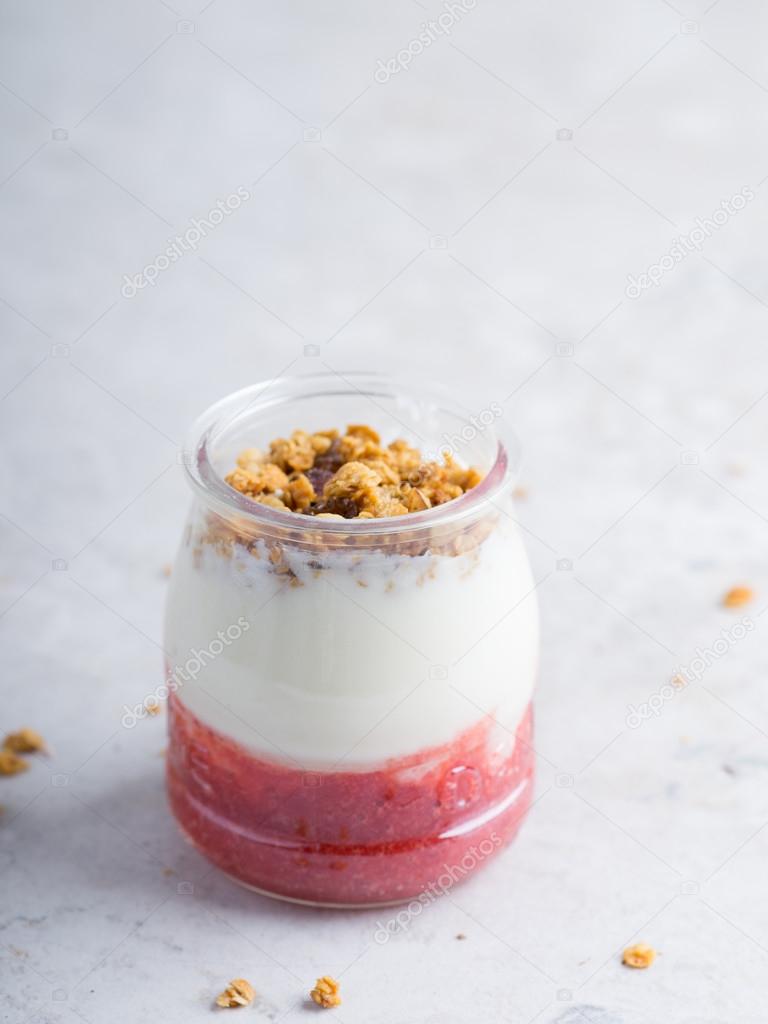 Yogurt with granola and strawberry pure in a jar