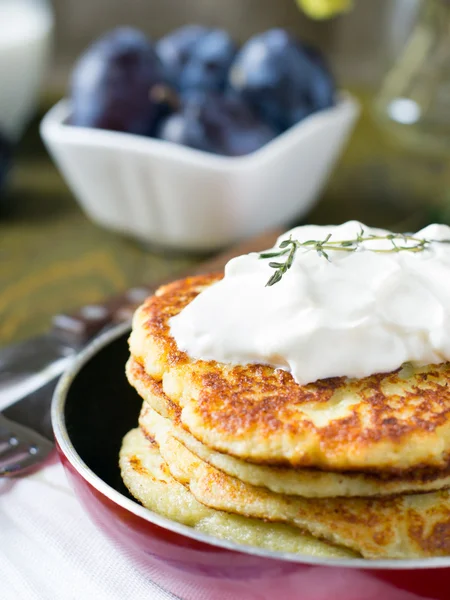 Kartoffelpuffer in einer Pfanne mit saurer Sahne — Stockfoto