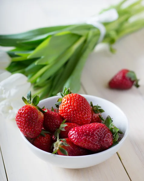 Erdbeeren mit weißen Tulpen — Stockfoto