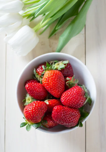 Erdbeeren mit weißen Tulpen — Stockfoto