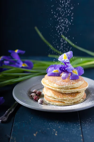 Pfannkuchen mit Blumen auf dem Tisch — Stockfoto