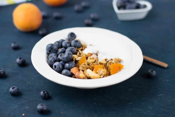 Мюсли с йогуртом, черникой и сушеными абрикосами — стоковое фото