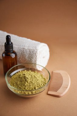 Cam kasede kına mhendi renkli toz ve bej arka plan manzarasında ahşap tarak. Ayurvedic saç bakım ürünleri. Doğal bakım ve saç boyama.