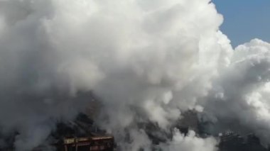 Drone fly thrue toxic enterprise chimneys tubing against the sky background release smoke. Factory pollutes environment. Aerial view. Ecology disaster. Azovstal. Mariupol, Ukraine