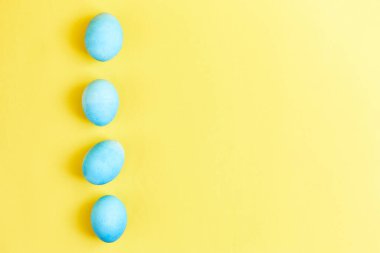Mutlu Paskalyalar. Yumurta bölmesinde mavi renge boyanmış tavuk yumurtaları. Tatil için hazırlık. Sarı arkaplan kopyalama alanı
