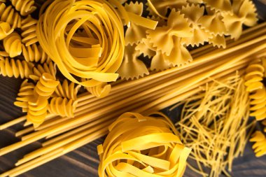 Koyu ahşap arka planda çeşitli makarna karışımları. İtalyan yemeği.