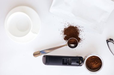 Homemade coffee preparation. Fresh roasted coffee, holder and white cup on white background
