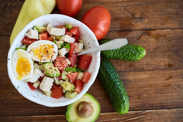 Taze sebzeli, yumurtalı ve tavuklu yaz salatası. Salatalıklı taze salata, domates, avokado, tohum ve kırmızı biber. Sağlıklı diyet yemekleri