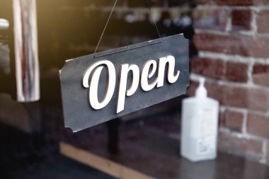 Covid-19 salgını sırasında kafenin ve dezenfekte şişesinin önünde açık tabela asılı. İş hizmeti ve gıda konsepti. 