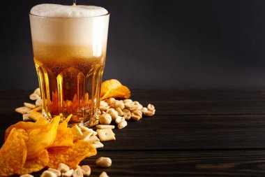 Bira ve abur cuburlar ahşap masada. Fındık, cips, kraker. El yapımı bira. Bira tahtası.