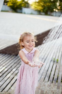 Plaj duşuyla oynayan duygusal komik kız. Sıcak yaz günü. Yaz alıntıları