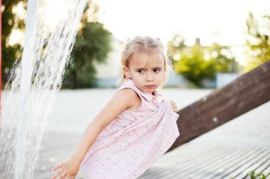 Plaj duşuyla oynayan duygusal komik kız. Sıcak yaz günü. Yaz alıntıları