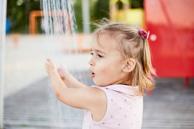 Plaj duşuyla oynayan duygusal komik kız. Sıcak yaz günü. Yaz alıntıları