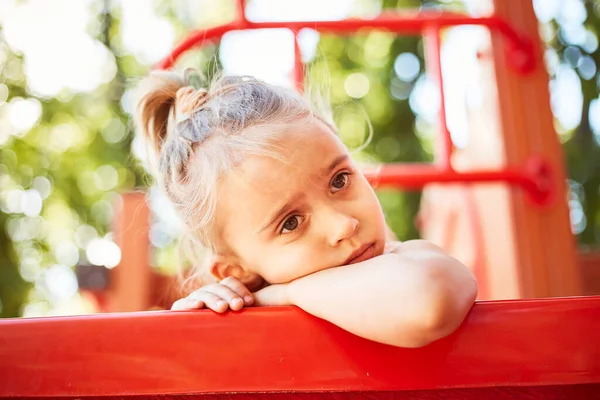 Yazın açık hava parkında tek başına oynayan beyaz tatlı bir kız. Oyun parkında oynayan duygusal, komik kız.. 