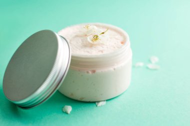 Taze kiraz çiçekli beyaz cilt kremi kavanozu. Kozmetik şişeleri. Botanik spa tedavisi hassas cilt. turkuaz arkaplan
