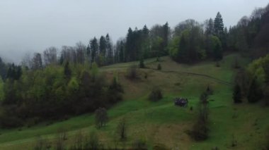 İnsansız hava aracı Karpat Dağları 'ndaki küçük dağ kulübesinde uçuyor. Bahar dağlarında sabah sisi.