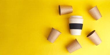 Sıfır israfının modern yolu. Tek kullanımlık bambu kabı bir sürü tek kullanımlık kağıt bardağa karşı. Kahve ve ekoloji. Kopyalama alanı olan sarı pankart