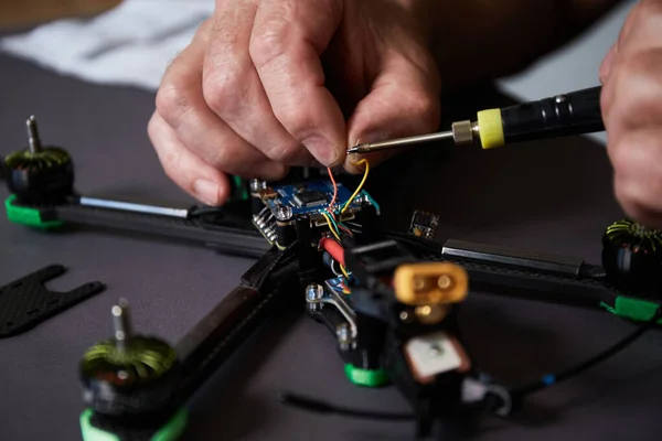 İnsan ellerinin parçaları kullanarak insansız hava aracını bir araya getirmesini araçları kullanarak, yüksek hızda yarışan kuadkopteri uçuş için hazırlamasını istiyorum. Eğitim sürecinden önce İHA 'yı onar.