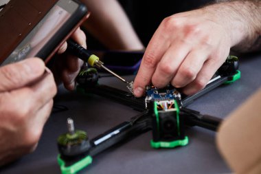 İnsan ellerinin parçaları kullanarak insansız hava aracını bir araya getirmesini araçları kullanarak, yüksek hızda yarışan kuadkopteri uçuş için hazırlamasını istiyorum. Eğitim sürecinden önce İHA 'yı onar.