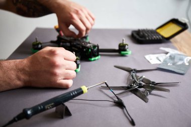 İnsan ellerinin parçaları kullanarak insansız hava aracını bir araya getirmesini araçları kullanarak, yüksek hızda yarışan kuadkopteri uçuş için hazırlamasını istiyorum. Eğitim sürecinden önce İHA 'yı onar.